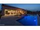 Backyard pool and covered patio area at dusk at 18016 E Wolf Tree Ln, Rio Verde, AZ 85263