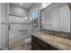 Elegant bathroom featuring a glass shower, decorative tile accents, and a granite vanity with a stylish mirror at 18016 E Wolf Tree Ln, Rio Verde, AZ 85263