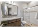 Well-lit bathroom featuring a glass shower with a built-in seat, granite counter top and a dark wood cabinet at 18016 E Wolf Tree Ln, Rio Verde, AZ 85263