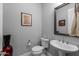 Cozy powder room featuring pedestal sink, framed mirror, and stylish accessories, creating a welcoming space at 18016 E Wolf Tree Ln, Rio Verde, AZ 85263