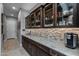 Functional butler's pantry with granite countertops, custom cabinetry, and space for a coffee bar at 18016 E Wolf Tree Ln, Rio Verde, AZ 85263