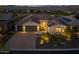 An eye-level view shows the facade of the house with its garage, well-lit driveway, and landscaped front yard at 18016 E Wolf Tree Ln, Rio Verde, AZ 85263