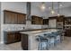 A wide shot reveals the open kitchen layout with a large island, modern appliances, and stylish pendant lighting at 18016 E Wolf Tree Ln, Rio Verde, AZ 85263