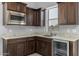 Kitchenette featuring stainless steel microwave, dark cabinets, a sink, and a mini fridge at 18016 E Wolf Tree Ln, Rio Verde, AZ 85263