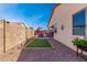 Backyard featuring an outdoor kitchen, seating area, artificial turf, and well-maintained landscaping for relaxation at 18146 W Tina Ln, Surprise, AZ 85387