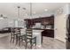 Modern kitchen featuring granite countertops, dark wood cabinets and an island with seating at 18146 W Tina Ln, Surprise, AZ 85387