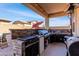 Outdoor kitchen with a built-in grill, stainless steel appliances, and a covered patio area perfect for entertaining at 18146 W Tina Ln, Surprise, AZ 85387