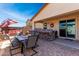 A stone patio features a dining area and outdoor seating underneath patio cover, creating a wonderful entertainment space at 18146 W Tina Ln, Surprise, AZ 85387