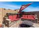 Outdoor seating area with comfortable red cushioned seating, a fire pit table, and a stylish outdoor ambiance at 18146 W Tina Ln, Surprise, AZ 85387