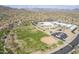 Aerial view showcases a baseball field near a school and residential neighborhood with mountain views at 1828 W Hemingway Ln, Anthem, AZ 85086