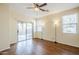 Bedroom with wood floors, two windows, sliding glass door, and ceiling fan at 1828 W Hemingway Ln, Anthem, AZ 85086