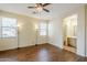 Bedroom with wood floors, two windows, ceiling fan, and view into bathroom at 1828 W Hemingway Ln, Anthem, AZ 85086