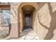 Inviting front entry featuring an arched doorway and covered porch at 1828 W Hemingway Ln, Anthem, AZ 85086