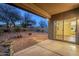 Covered patio overlooking a low-maintenance backyard with desert landscaping, a fire pit, and privacy walls at 1828 W Hemingway Ln, Anthem, AZ 85086