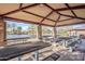 Covered picnic pavilion with multiple tables and seating overlooking a scenic pond and playground in the park at 1828 W Hemingway Ln, Anthem, AZ 85086