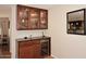 Elegant bar area showcasing custom cabinetry, glass display shelves, and a built-in wine refrigerator at 1920 E Manzanita Dr, Phoenix, AZ 85020