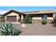 Single-story home showcasing desert landscaping, a two-car garage, and charming stone accents on the facade at 1920 E Manzanita Dr, Phoenix, AZ 85020