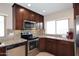 Modern kitchen featuring granite countertops, dark wood cabinets, stainless steel appliances, and ample natural light at 1920 E Manzanita Dr, Phoenix, AZ 85020