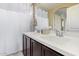 Bright bathroom featuring double sinks, modern fixtures, and a large mirror at 2013 N 77Th Gln, Phoenix, AZ 85035