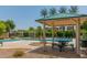 Relaxing community pool area with shaded picnic tables and lush landscaping at 2013 N 77Th Gln, Phoenix, AZ 85035