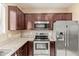 Modern kitchen featuring stainless steel appliances, granite countertops, and dark wood cabinets for a sleek look at 2013 N 77Th Gln, Phoenix, AZ 85035