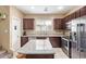 Well-equipped kitchen with stainless steel appliances, granite countertops, and ample cabinet space for storage at 2013 N 77Th Gln, Phoenix, AZ 85035