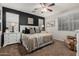 Bedroom with black accent wall, neutral furnishings, ceiling fan and carpeted flooring at 20916 E Desert Hills Blvd, Queen Creek, AZ 85142