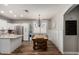 Open-concept kitchen and dining area featuring white cabinets, stainless steel appliances, and elegant chandelier lighting at 20916 E Desert Hills Blvd, Queen Creek, AZ 85142