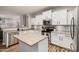 A kitchen with white cabinets, stainless steel appliances, island and view into living area at 20916 E Desert Hills Blvd, Queen Creek, AZ 85142