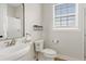 Bright bathroom featuring a pedestal sink, modern toilet, and a window for natural light at 2457 W Phillips Rd, Queen Creek, AZ 85144