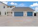 Oversized 3-car garage featuring modern blue doors and a spacious concrete driveway for easy vehicle storage at 2457 W Phillips Rd, Queen Creek, AZ 85144