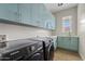 Well-equipped laundry room featuring contemporary cabinets, plenty of counter space, and modern appliances at 2457 W Phillips Rd, Queen Creek, AZ 85144