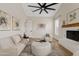 Cozy living room with a fireplace, comfortable seating, and a modern ceiling fan at 2457 W Phillips Rd, Queen Creek, AZ 85144