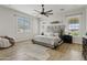 Spacious main bedroom with large windows, a ceiling fan, and stylish decor at 2457 W Phillips Rd, Queen Creek, AZ 85144