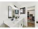 Bright bathroom featuring dual sinks with black hardware, a walk-in closet, and modern lighting at 2923 N 63Rd St, Mesa, AZ 85215