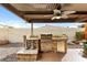 Covered outdoor kitchen featuring a built-in grill, granite counters, and a ceiling fan at 2923 N 63Rd St, Mesa, AZ 85215