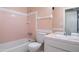 Retro pink bathroom featuring a tub, toilet, and vanity, offering a glimpse into vintage charm at 2928 W Cactus Rd, Phoenix, AZ 85029