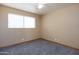 This bedroom features neutral carpet, ceiling fan, and window providing natural light at 2928 W Cactus Rd, Phoenix, AZ 85029