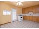 A view of the kitchen area showing light oak cabinets, tile floors, white appliances and access to an exit at 2928 W Cactus Rd, Phoenix, AZ 85029