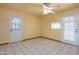 A view of the living area showing tile floors, ceiling fan and two exits, one with window at 2928 W Cactus Rd, Phoenix, AZ 85029