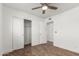 A bedroom featuring wood floors, closet with bi-fold doors, and entry to additional room at 3027 S Clementine Dr, Tempe, AZ 85282