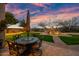 Beautiful backyard with outdoor dining, fireplace, and green lawn at sunset at 32754 N 15Th Gln, Phoenix, AZ 85085