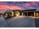 Well-lit home exterior boasts a three-car garage, manicured landscaping, and stone accents creating curb appeal at 32754 N 15Th Gln, Phoenix, AZ 85085