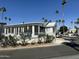 Charming home featuring a covered patio, landscaping, and a view of palm trees in a well-maintained community at 328 E Aztec Blvd, Mesa, AZ 85205