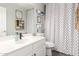 Neutral bathroom with white vanity, patterned shower curtain and decorative shelves at 3284 W Five Mile Peak Dr, San Tan Valley, AZ 85144