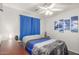 Simple bedroom with ceiling fan, wood floors, and ocean themed decor at 3284 W Five Mile Peak Dr, San Tan Valley, AZ 85144