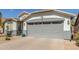 Two car garage featuring gray accents, exterior lighting, and xeriscaped front yard at 3284 W Five Mile Peak Dr, San Tan Valley, AZ 85144