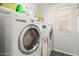 Bright laundry room with white washer and dryer set, storage shelf, and modern dark gray tile flooring at 3284 W Five Mile Peak Dr, San Tan Valley, AZ 85144