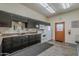 A bright kitchen featuring dark cabinets, a white microwave, oven, refrigerator, and a stainless steel sink at 3330 E Main St # 7, Mesa, AZ 85213