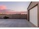 View of the metal barn with a concrete area, block wall, and mountain view in the distance at dusk at 38301 N 15Th Ave, Phoenix, AZ 85086